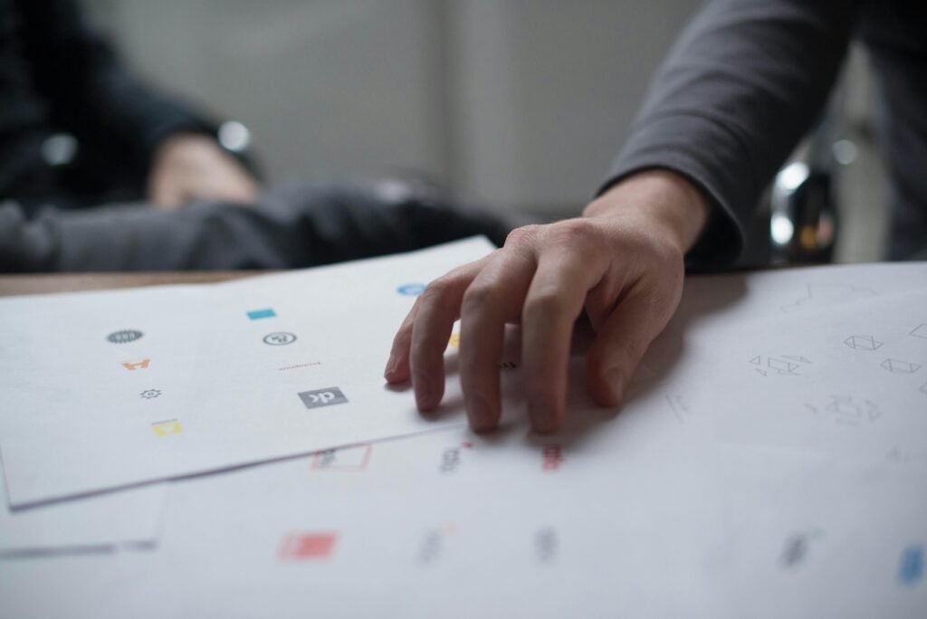 pexels photo 17845 A close-up shot of a hand reviewing various logo designs on paper, ideal for business concepts.